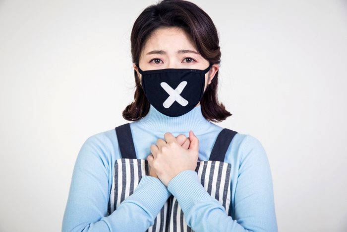 엑스표시가 된 검정 마스크를 끼고 있는 여성
