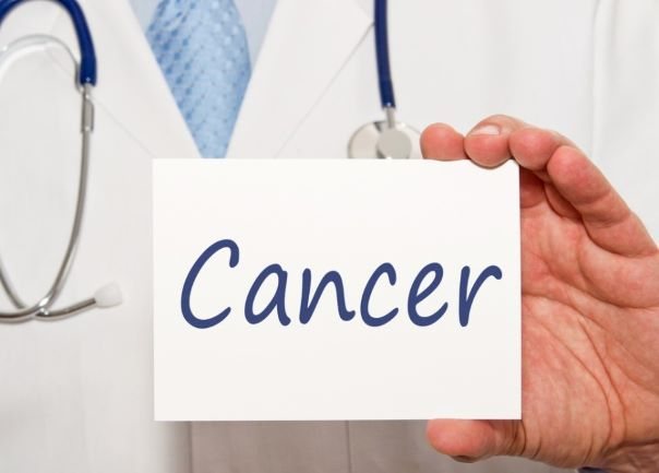 의사가 암이라고 쓰여져 있는 카드를 손에 들고 있다.