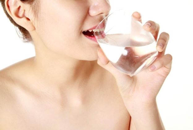 컵에 든 물을 먹고 있는 여성